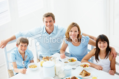 stock-photo-12716131-happy-family-sitting-together-at-breakfast-table